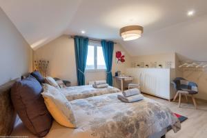 a bedroom with two beds with blue curtains at Chambre Rambouillet, Au Domaine du Cerf in Vyans