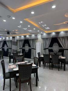 a dining room with tables and chairs in a restaurant at the best stay hotel in peshawar in Peshawar