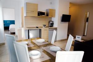 a kitchen and dining room with a table and chairs at Résidence Thalacap in Cap d'Agde