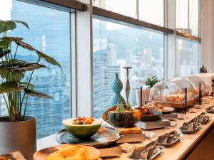 a buffet of food on a table with a view of a city at Kobe Marriott Hotel in Kobe