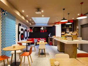 un restaurante de comida rápida con mesas y sillas en Hotel ibis Lisboa Liberdade, en Lisboa