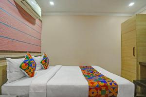 a bedroom with a large bed with colorful pillows at FabHotel Tanvi Grand in Visakhapatnam
