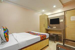 a hotel room with a bed and a television at FabHotel Tanvi Grand in Visakhapatnam