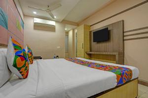 a bedroom with a large bed and a flat screen tv at FabHotel Tanvi Grand in Visakhapatnam