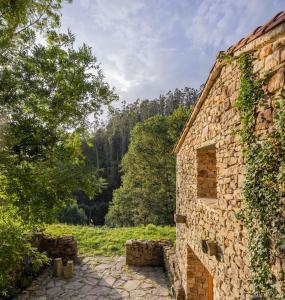an old stone building with ivy growing on it at Casa Mínima retiro Passivhaus in Selaya
