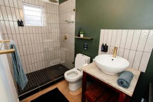 a bathroom with a sink and a toilet and a shower at Park Road Apartments in Howick +28 photos