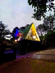 Arabian Holiday Resort Family Cottage One Room Two Bed في ادوكي: منزل صغير بسقف أخضر مع أضواء