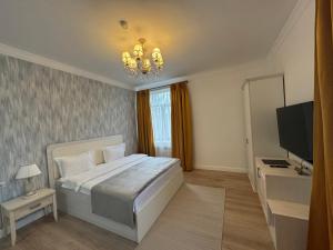 a bedroom with a large bed and a television at Hotel Astoria in Astana