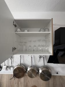 eine Gruppe von Töpfen und Pfannen, die auf einem Regal hängen in der Unterkunft A2 - Viel Platz für alle in Wernigerode