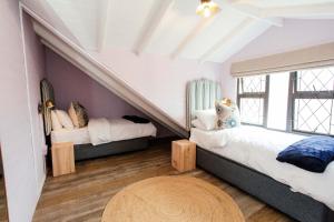 a attic room with two beds and a table at Park Road Apartments in Howick