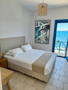 a bedroom with a bed with a view of the ocean at Agia Fotia Taverna in Kerames