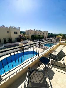 a balcony with two chairs and a swimming pool at Sorelia Latchi Villas 1- Merope Irena in Polis Chrysochous
