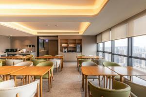 a restaurant with tables and chairs and windows at 先泽酒店 in Huadu