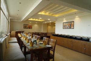 ein Speisesaal mit Tischen und Stühlen und einer Bar in der Unterkunft Shimla Golf Resorts in Shimla