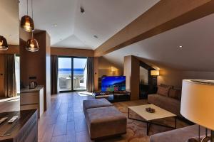 ein Wohnzimmer mit Sofa und Fernseher in der Unterkunft Hotel Riva by Aycon in Petrovac na Moru