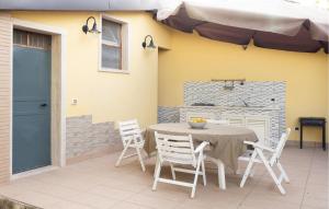 un tavolo e sedie su un patio con ombrellone di Stunning Home In Siracusa a Floridia