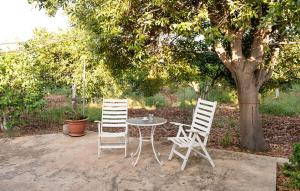 due sedie bianche e un tavolo sotto un albero di Stunning Home In Siracusa a Floridia
