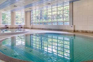 a swimming pool in a building with glass windows at Mayfield Hotel Seoul in Seoul