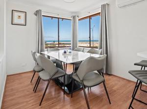 a dining room with a white table and chairs at Ocean Reef Marina by the Sea 4BR plus Study plus in Perth