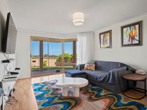 a living room with a couch and a table at Ocean Reef Marina by the Sea 4BR plus Study plus in Perth