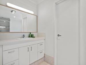 a white bathroom with a sink and a mirror at Ocean Reef Marina by the Sea 4BR plus Study plus in Perth +27 photos