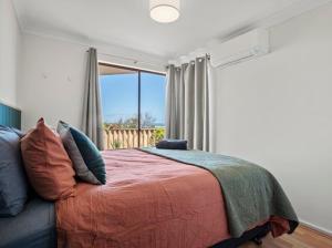 a bedroom with a bed and a large window at Ocean Reef Marina by the Sea 4BR plus Study plus in Perth