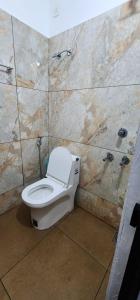 baño con aseo y pared de piedra en Wave, en Kochi