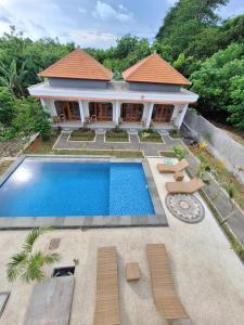 a villa with a swimming pool in front of a house at Lavanya Loka Balangan in Jimbaran