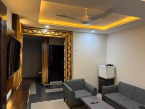 ein Wohnzimmer mit einer Couch und einem Deckenventilator in der Unterkunft Mahnoor Living Apartment Peshawar in Peschawar