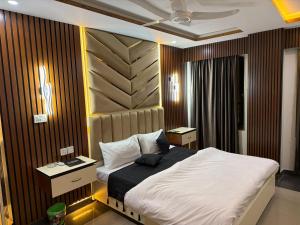 ein Schlafzimmer mit einem Bett und einer Holzwand in der Unterkunft Mahnoor Living Apartment Peshawar in Peschawar