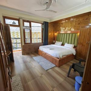 a bedroom with a bed with a green headboard at Qpoint hotel in Kasol