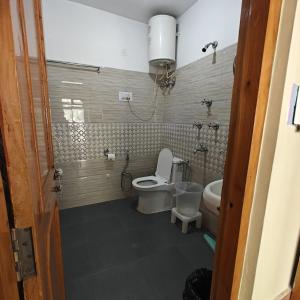 a bathroom with a toilet and a sink at Qpoint hotel in Kasol