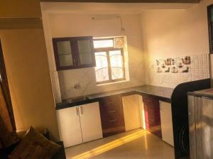 cocina con encimera y ventana en Avasa Homestay, en Thūr