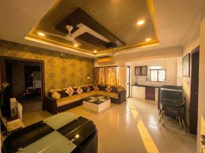 Una sala de estar con un sofá y una cocina. en Avasa Homestay, en Thūr