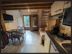 a kitchen and living room with a table and a couch at Le Mas des Condamines in Canet