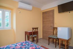 a bedroom with a bed and a desk and a door at Luisa S2 room B in Veli Lošinj