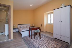 a bedroom with a bed and a desk and a chair at Luisa S2 room B in Veli Lošinj