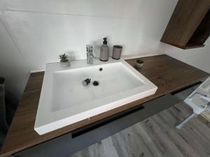 ein weißes Waschbecken im Bad mit einer Holztheke in der Unterkunft A2 - Viel Platz für alle in Wernigerode + 47 Fotos