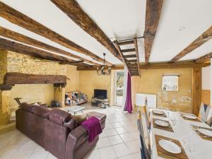 una sala de estar con un sofá y una mesa en Maison pour 5 - Grande jardin et terrasse - Jacuzzi, en Le Bos de Plazac