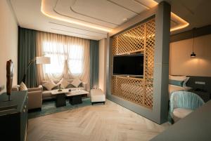 a room with a living room with a couch and a tv at Le Royal Plaza in Kenitra