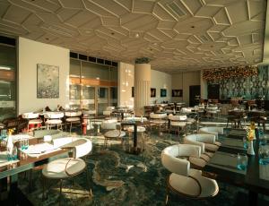 a restaurant with tables and chairs in a room at Le Royal Plaza in Kenitra