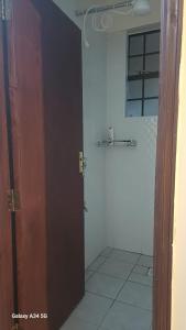 Homely Haven Apartment- Machakos في Machakos: باب مفتوح للحمام مع دش