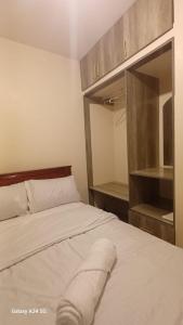 Homely Haven Apartment- Machakos في Machakos: غرفة نوم بسرير أبيض مع مرآة