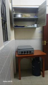 Homely Haven Apartment- Machakos في Machakos: طاولة صغيرة مع موقد في المطبخ