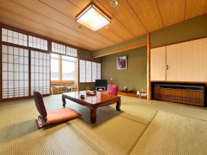 a large living room with a table and a chair at 秘湯花文 in Myoko