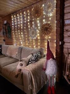 Ein Zimmer mit einer Couch, auf der eine Weihnachtsmannmütze und Lichterketten hängen. in der Unterkunft Ylläs Valokki - sauna, fireplace, Ylläs view in Ylläsjärvi