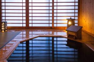 a pool of water with a candle in a room at 割烹旅館 清都 in Hongō