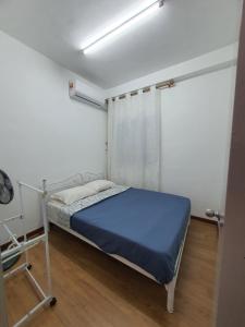 a bedroom with a bed with a blue mattress at JT Homestay in Kota Kinabalu