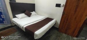 ein Schlafzimmer mit einem Bett mit weißen Laken und Kissen in der Unterkunft Shree chendur family Residency in Tiruvannāmalai