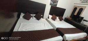 2 Betten in einem Hotelzimmer mit 2 in der Unterkunft Shree chendur family Residency in Tiruvannāmalai